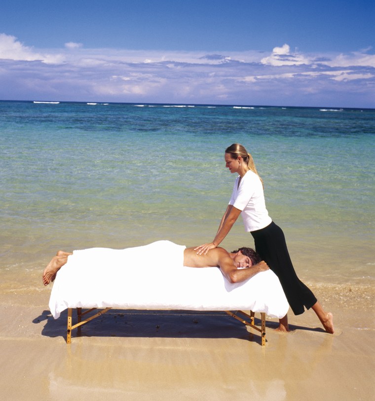 Massage therapist Ashley Siebring-Jones gives a massage on the beach.